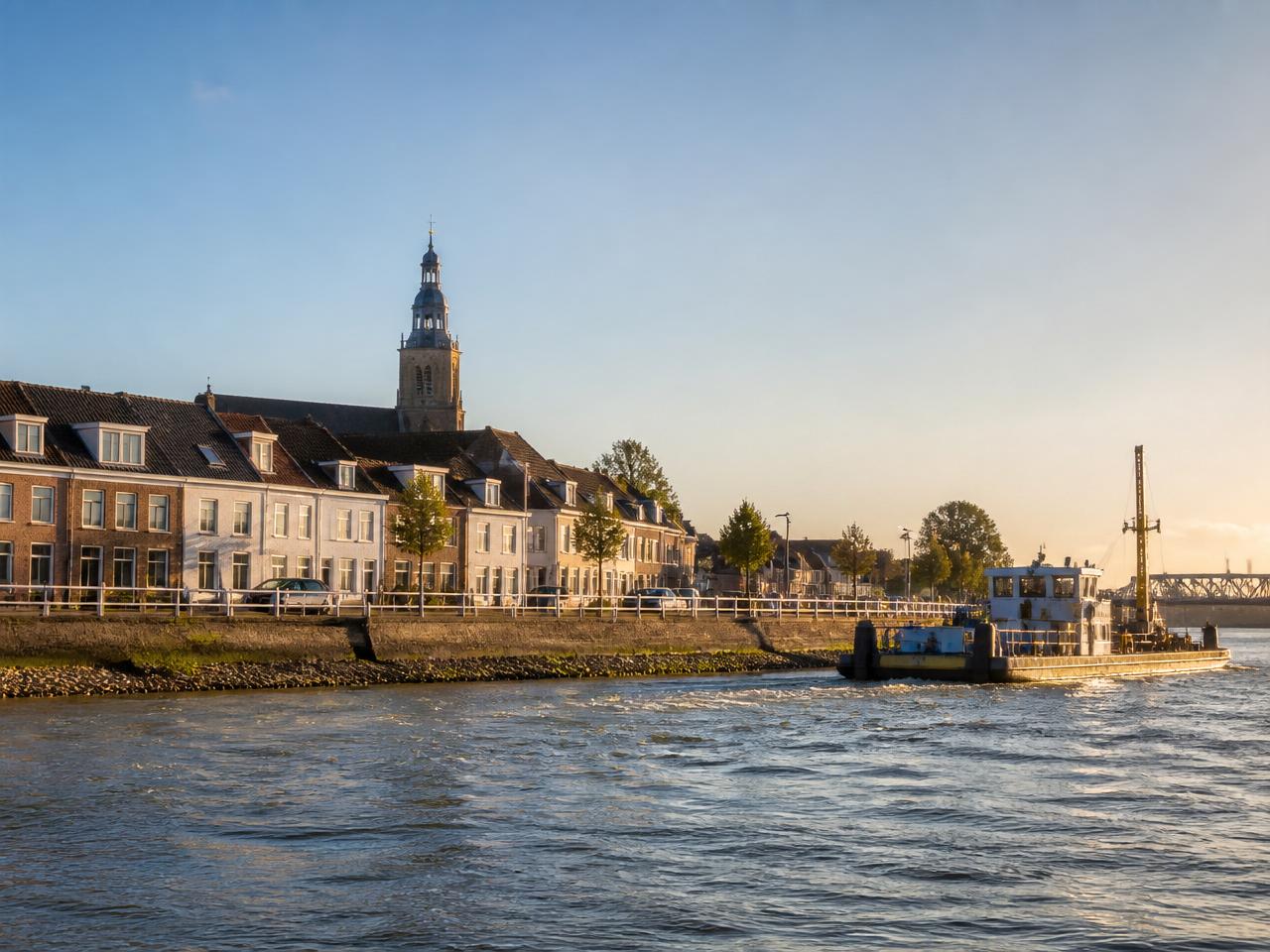 Karakteristieke dijkwoningen langs de Merwede in Sliedrecht met kerk en sleepboot